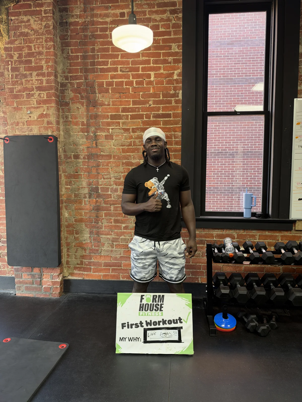 A Formhouse participant celebrating their first workout with a personal goal sign