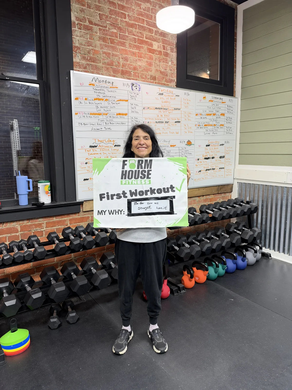 A Formhouse participant celebrating their first workout with a personal goal sign